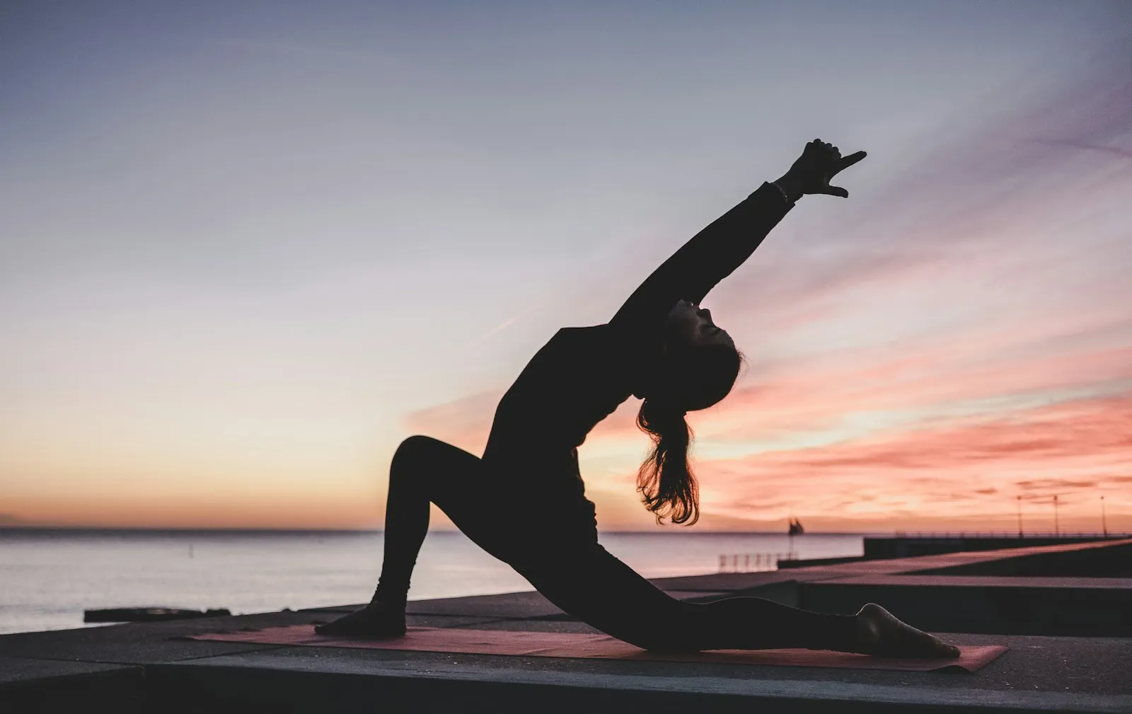 Personne en posture de yoga sur un tapis dans une salle calme